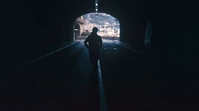 a person standing in a tunnel at night