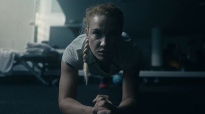 a woman is doing push ups in a dark room