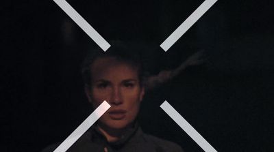 a woman standing in front of a black background