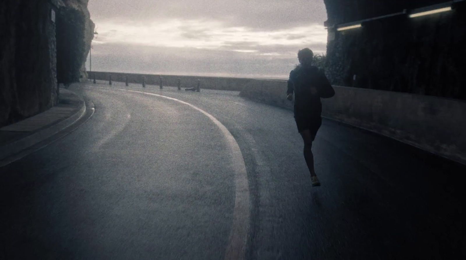 a person running down a road in the rain