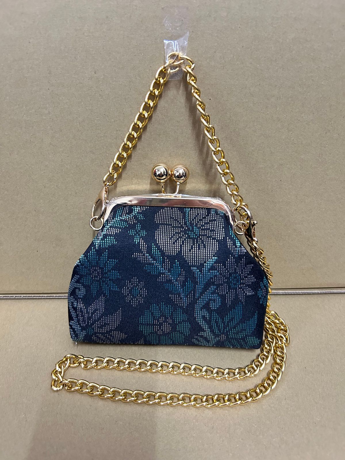 a blue purse with a chain hanging from it