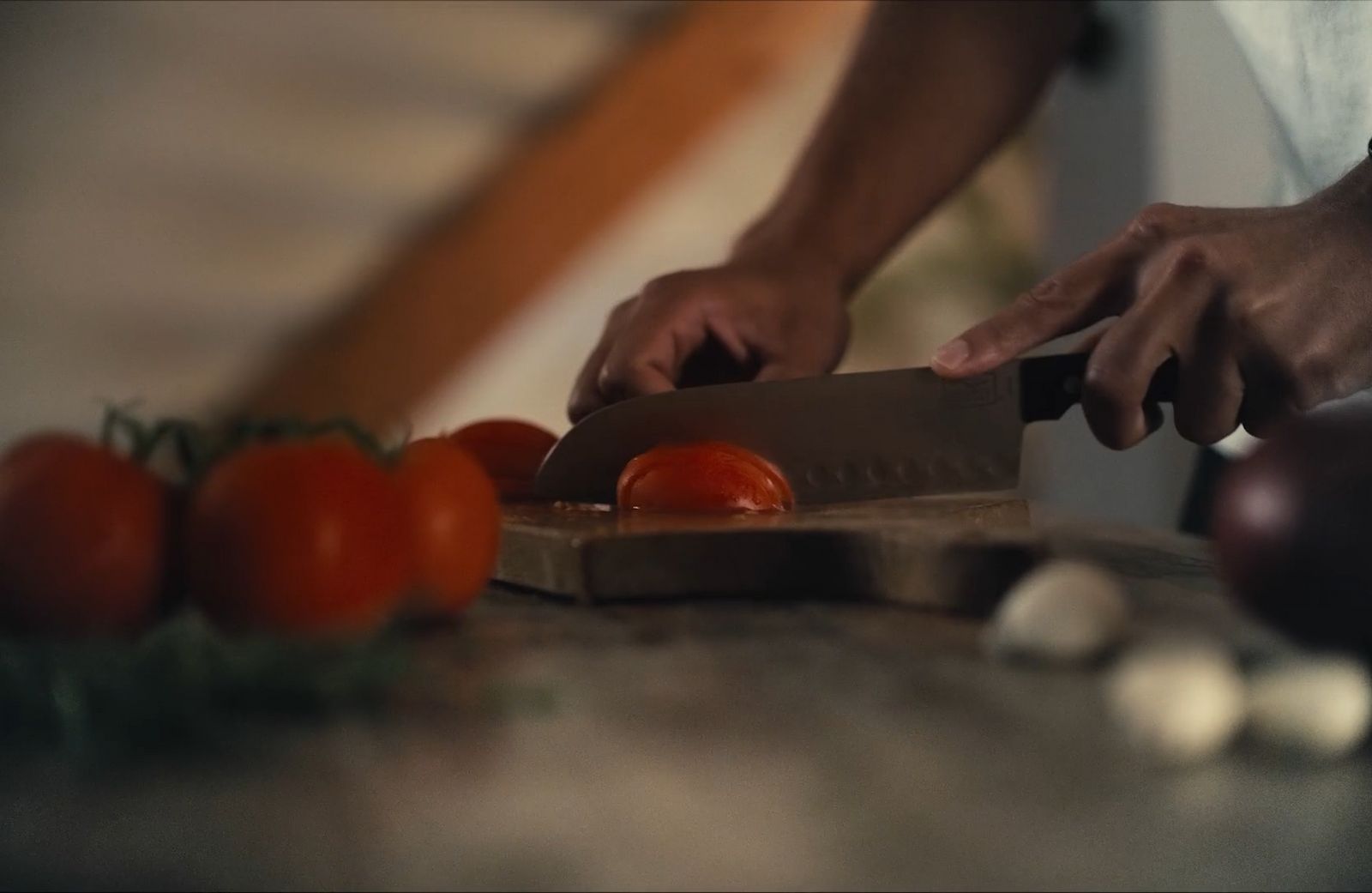 a person slicing tomatoes on a cutting board