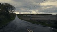 an empty road with a cloudy sky in the background