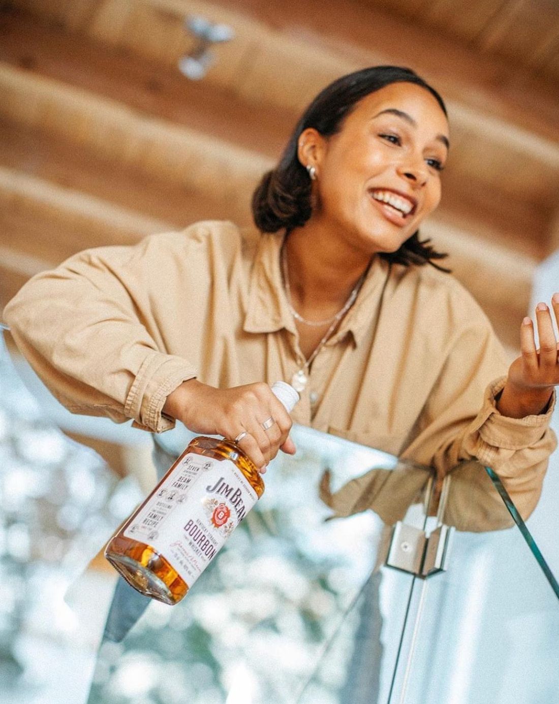 a woman is holding a bottle of whiskey