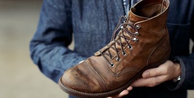 a man holding a pair of brown boots