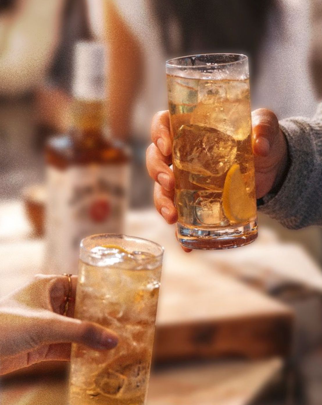 a person holding a glass of ice tea