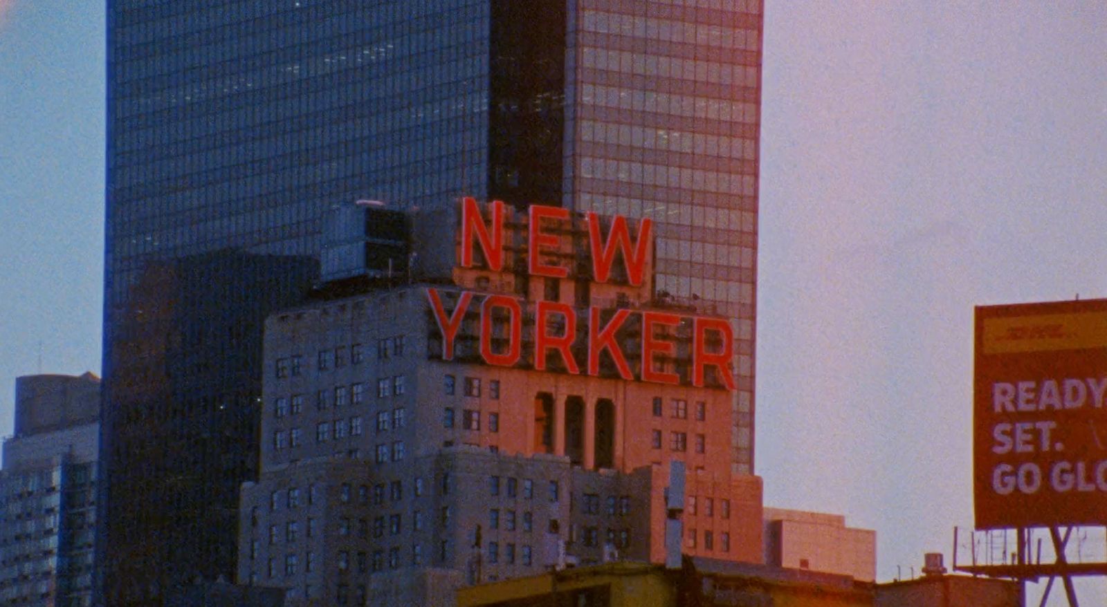 a very tall building with a neon sign on top of it