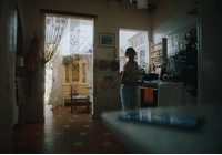 a woman standing in a kitchen next to a door