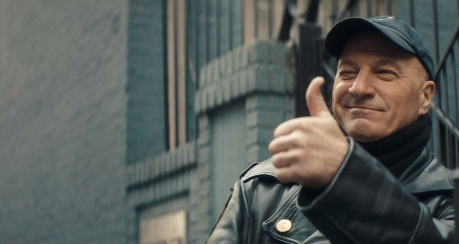 a man in a leather jacket giving a thumbs up