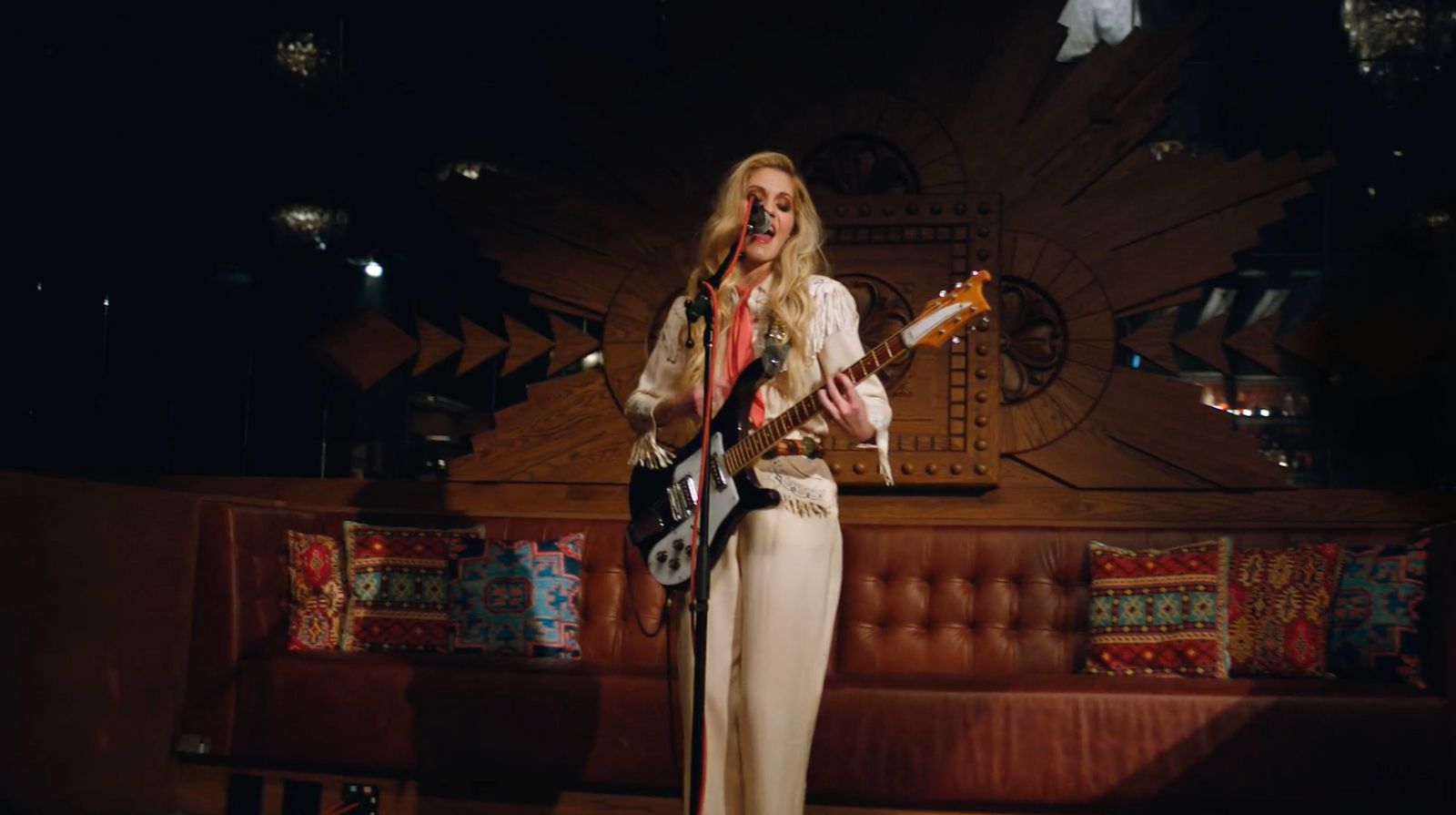 a woman standing on a stage with a guitar