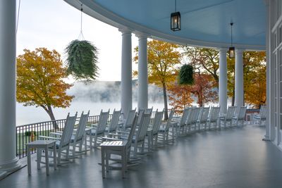 a row of white chairs sitting on top of a porch