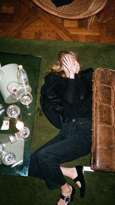 a woman laying on the floor next to a suitcase