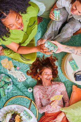 a group of women sitting on top of a green rug