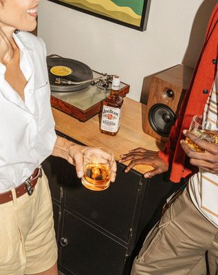 a man and a woman holding glasses of whiskey