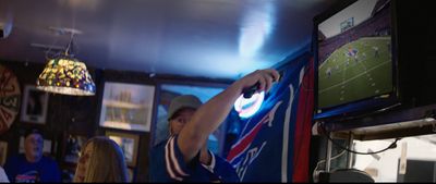 a man is playing a video game in a bar