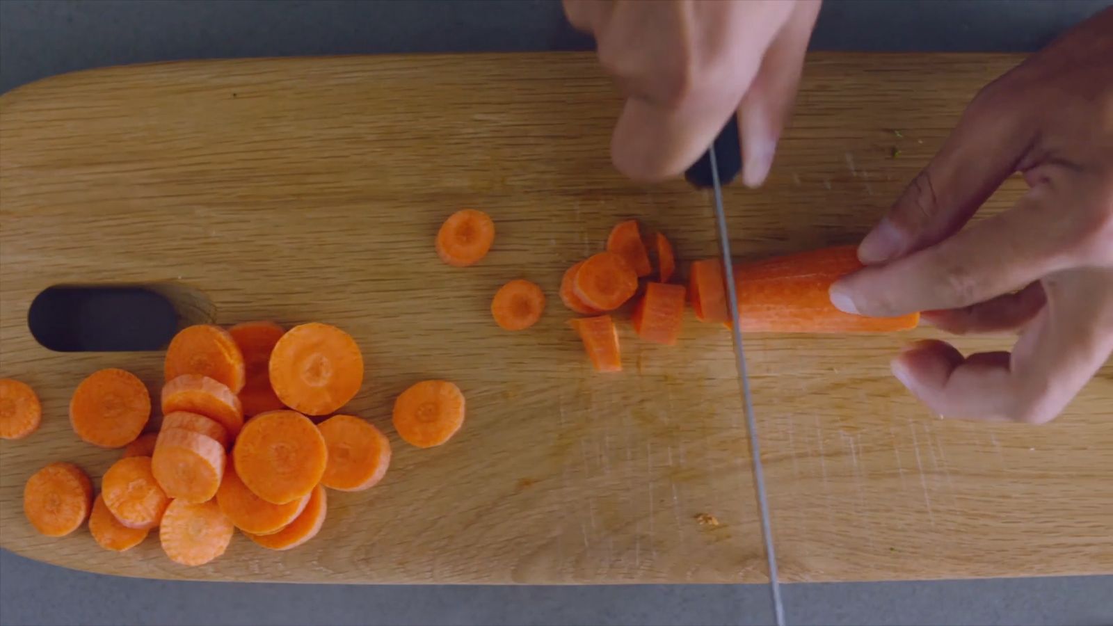 a person chopping carrots on a cutting board