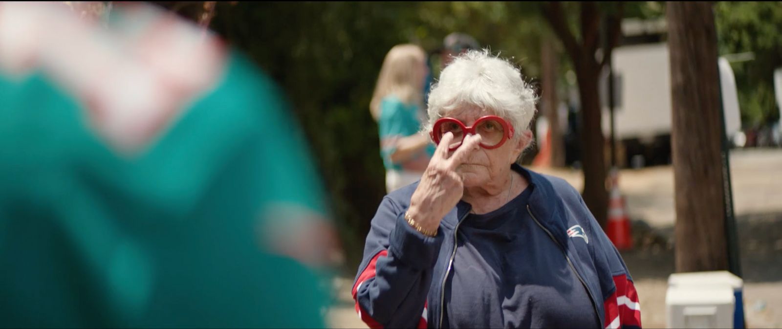 an older woman wearing red sunglasses and a blue jacket