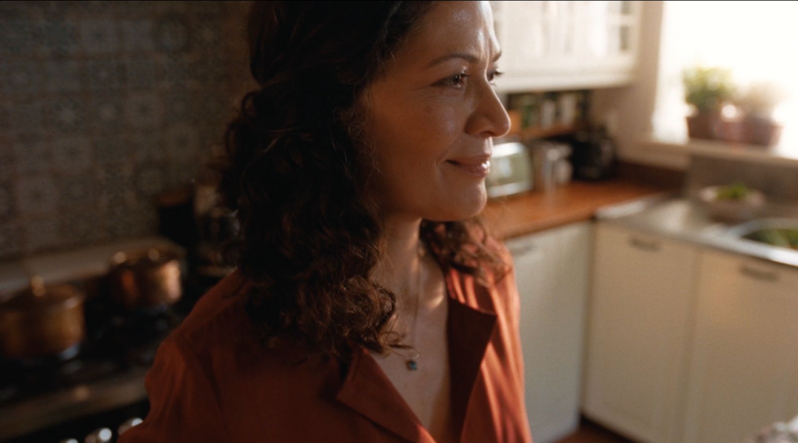 a woman standing in a kitchen next to a sink