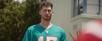 a man in a football uniform standing in front of a building