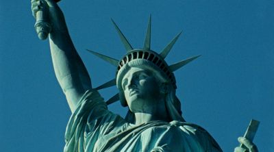 a statue of liberty holding a cell phone