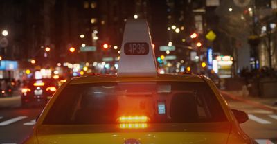 a yellow taxi cab is stopped at a red light