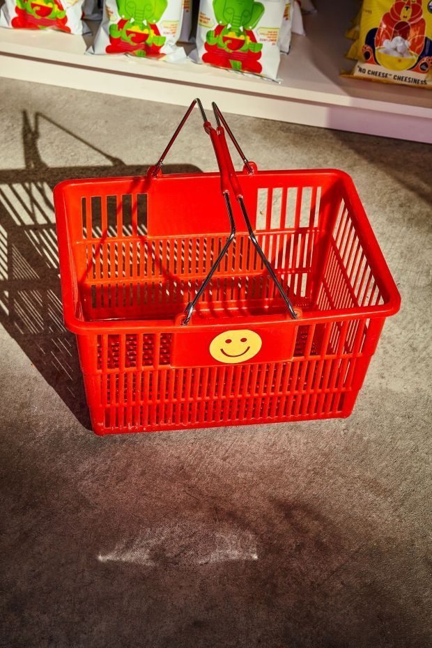 a red shopping basket with a smiley face on it