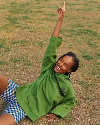 a young girl laying on the ground with her arms in the air