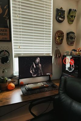 a desk with a computer and a chair in front of a window