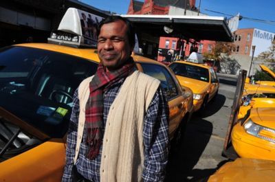 a man standing next to a row of taxis