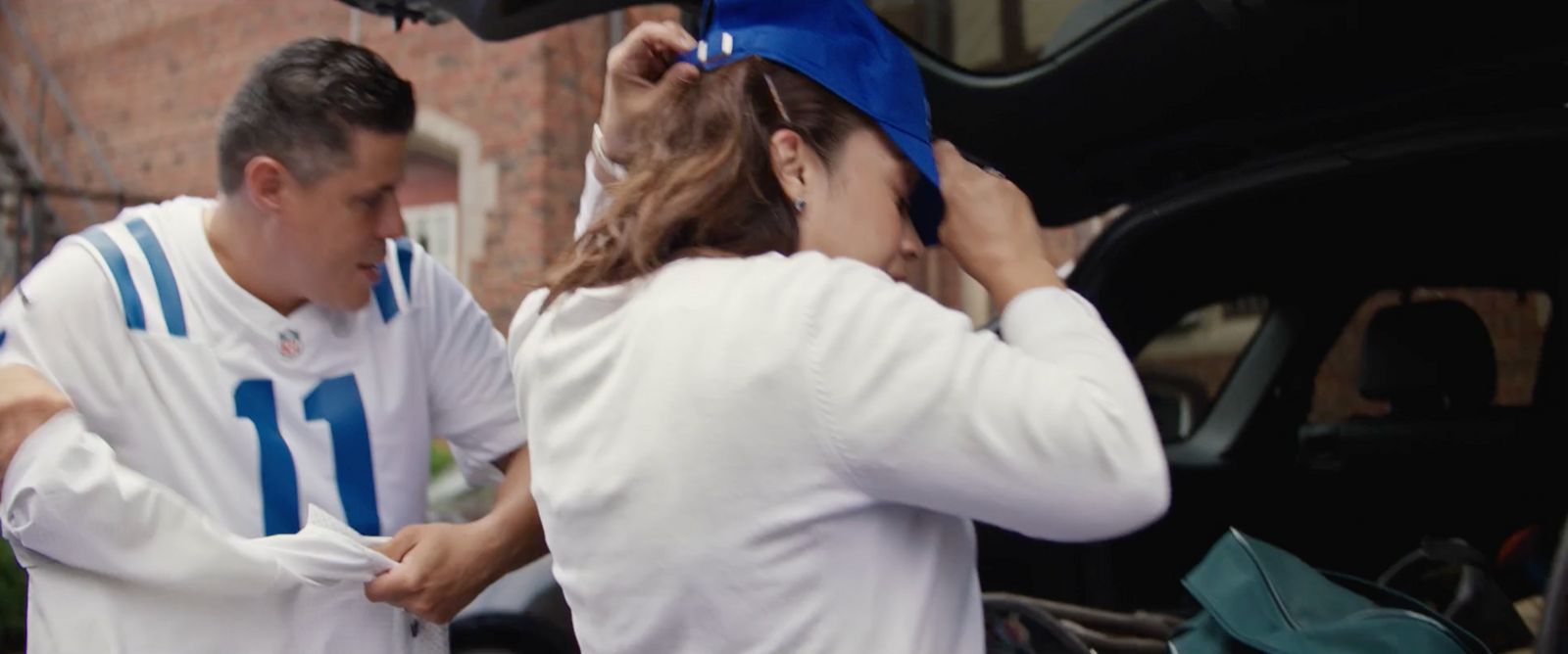 a couple of people that are standing in front of a car