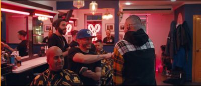 a group of men standing around a barber shop