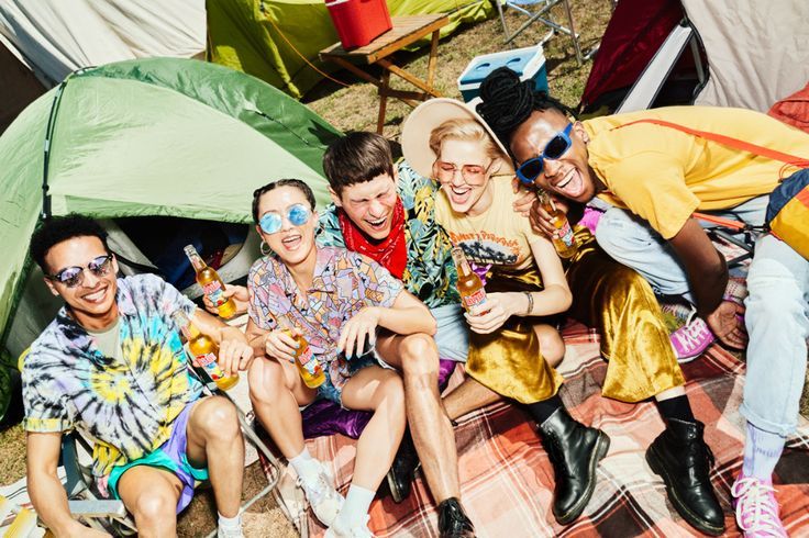 a group of people sitting next to each other on a blanket