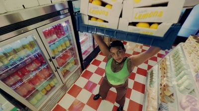 a woman standing in front of a refrigerator in a store