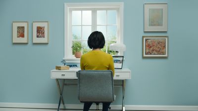 a woman sitting at a desk in front of a window