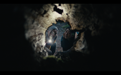 a couple of people standing next to each other in a cave