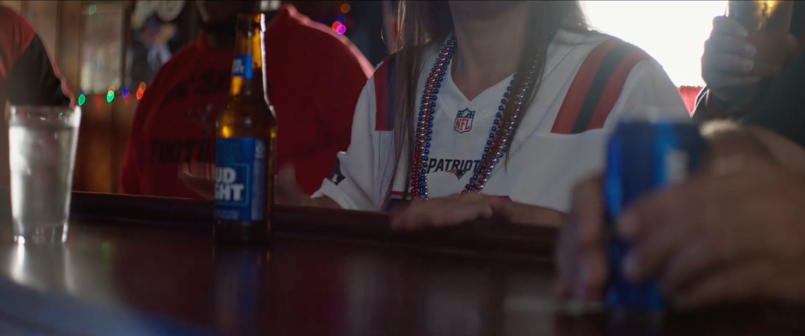 a person sitting at a bar with a bottle of beer