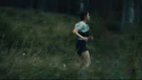 a man running through a field of tall grass