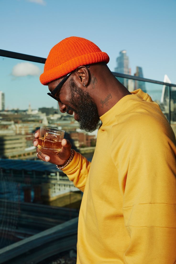 a man in an orange hat holding a drink