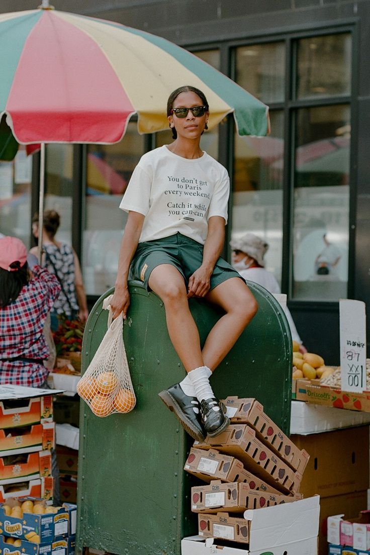 a woman sitting on top of a green box