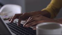 a close up of a person typing on a laptop