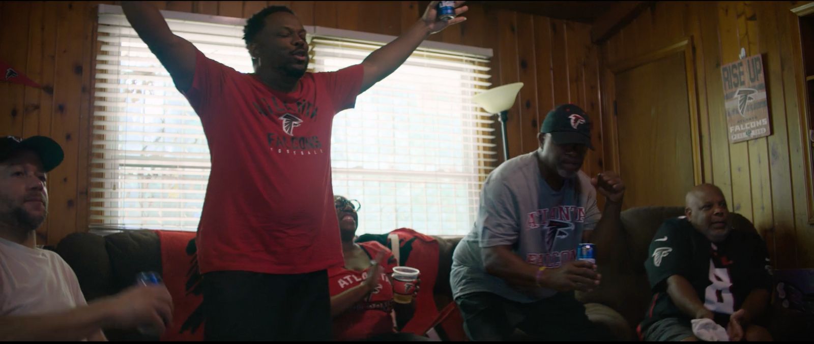 a group of men sitting in a living room next to each other