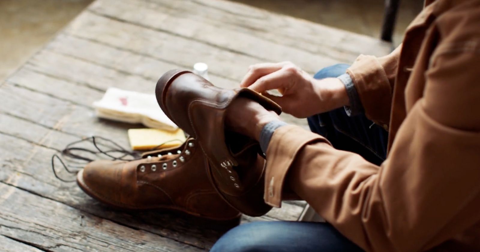 a person sitting on a wooden bench with a pair of shoes