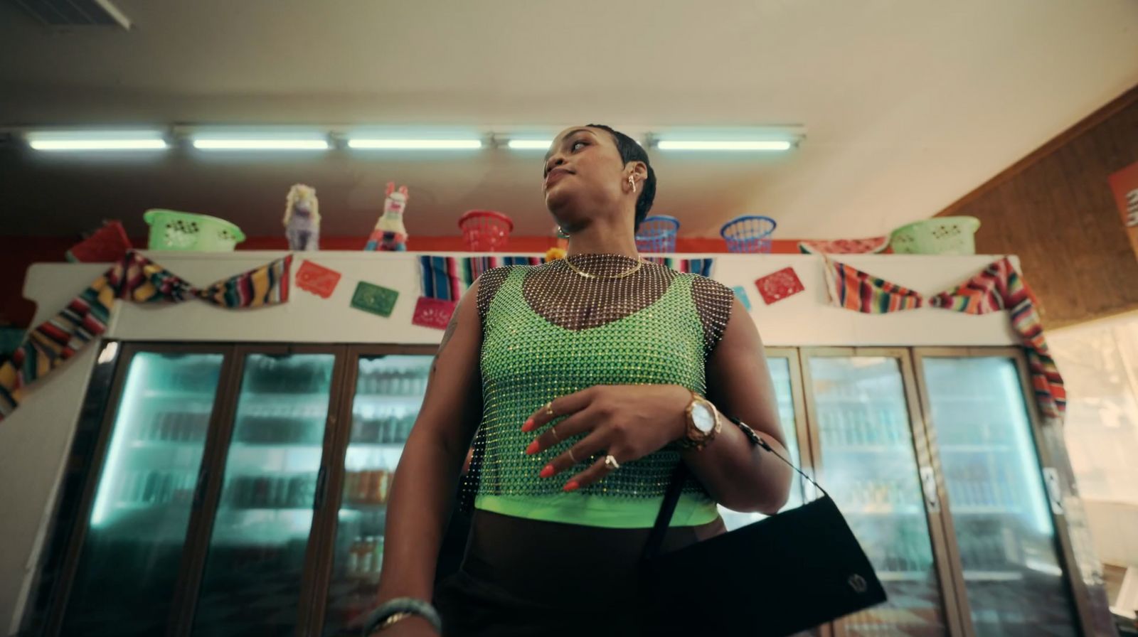 a woman in a green top standing in a kitchen