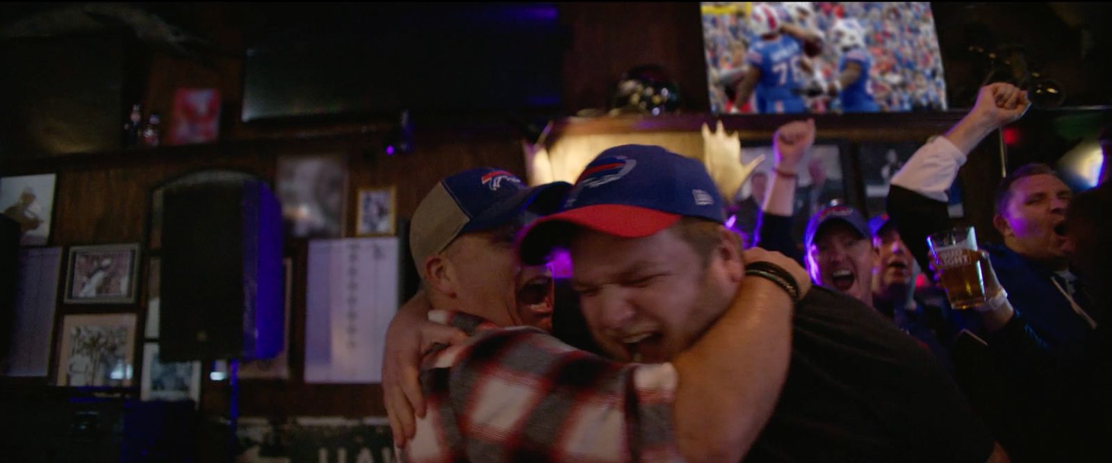 a man hugging another man in a bar