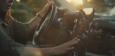 a woman driving a truck with her hands on the steering wheel