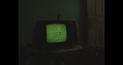 an old television with a green screen in a dark room