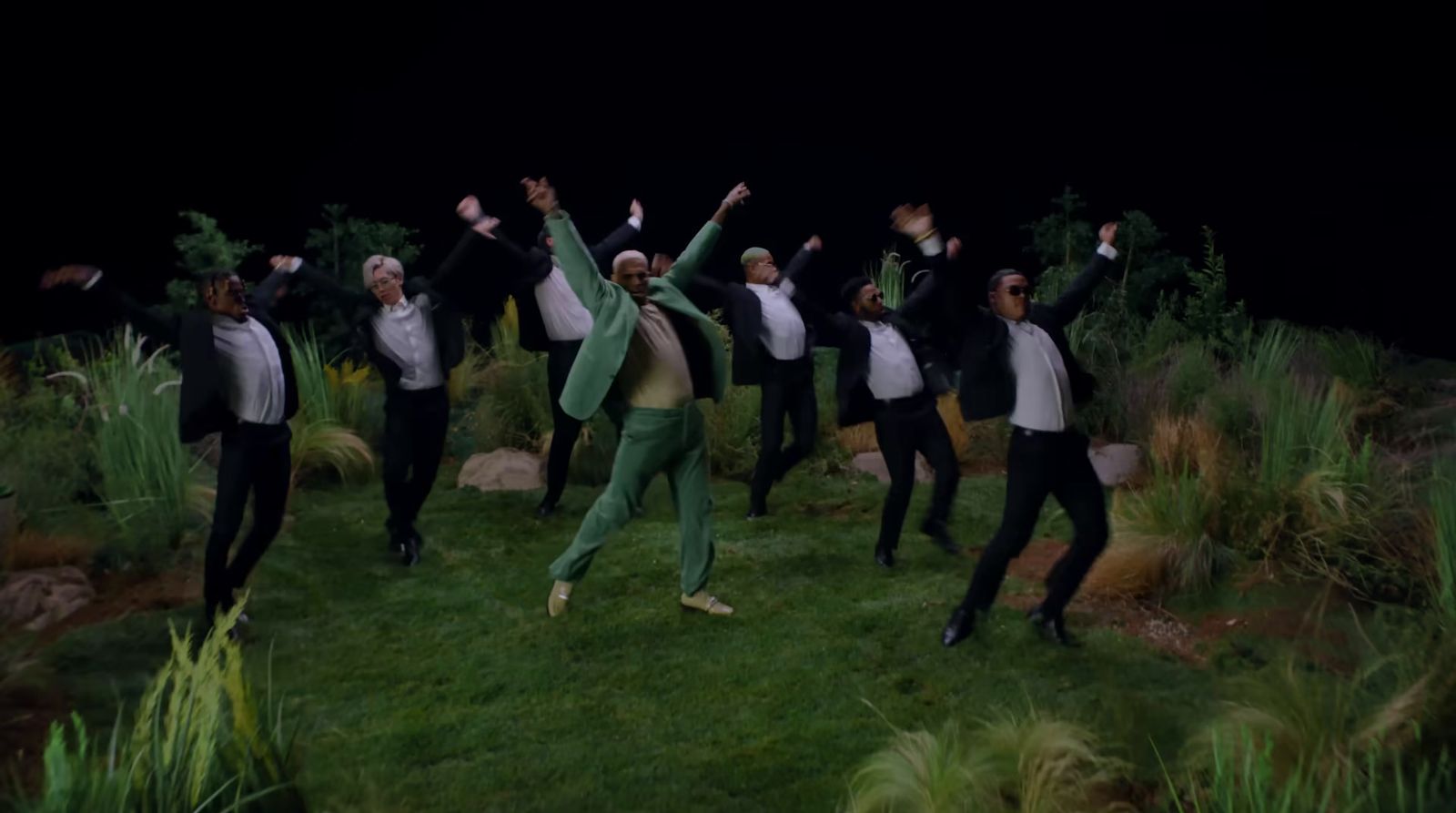 a group of people standing on top of a lush green field