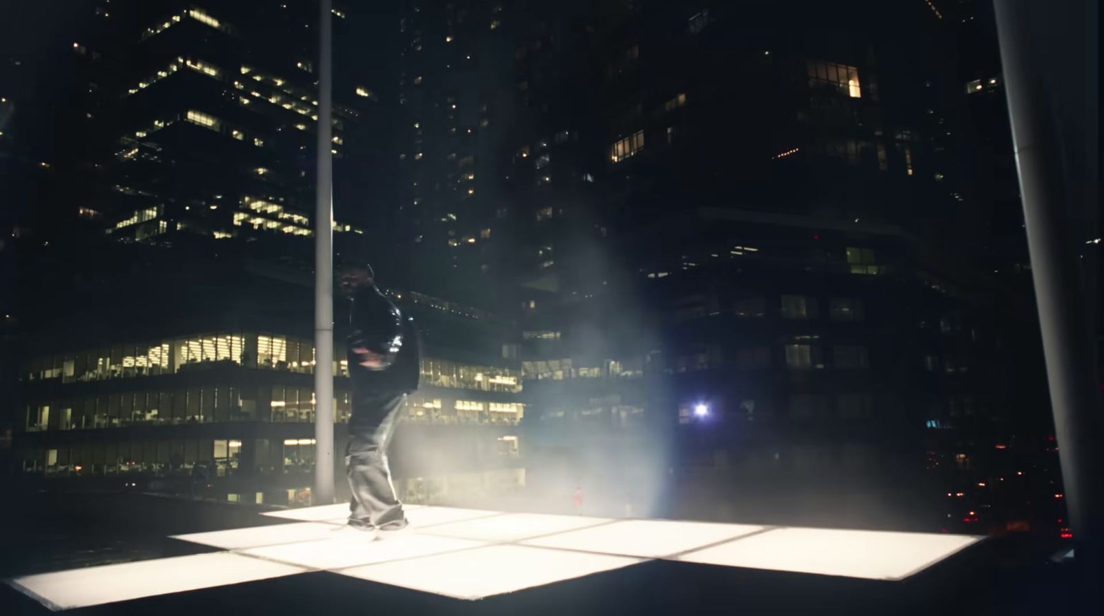 a person standing on a platform in the middle of a city at night