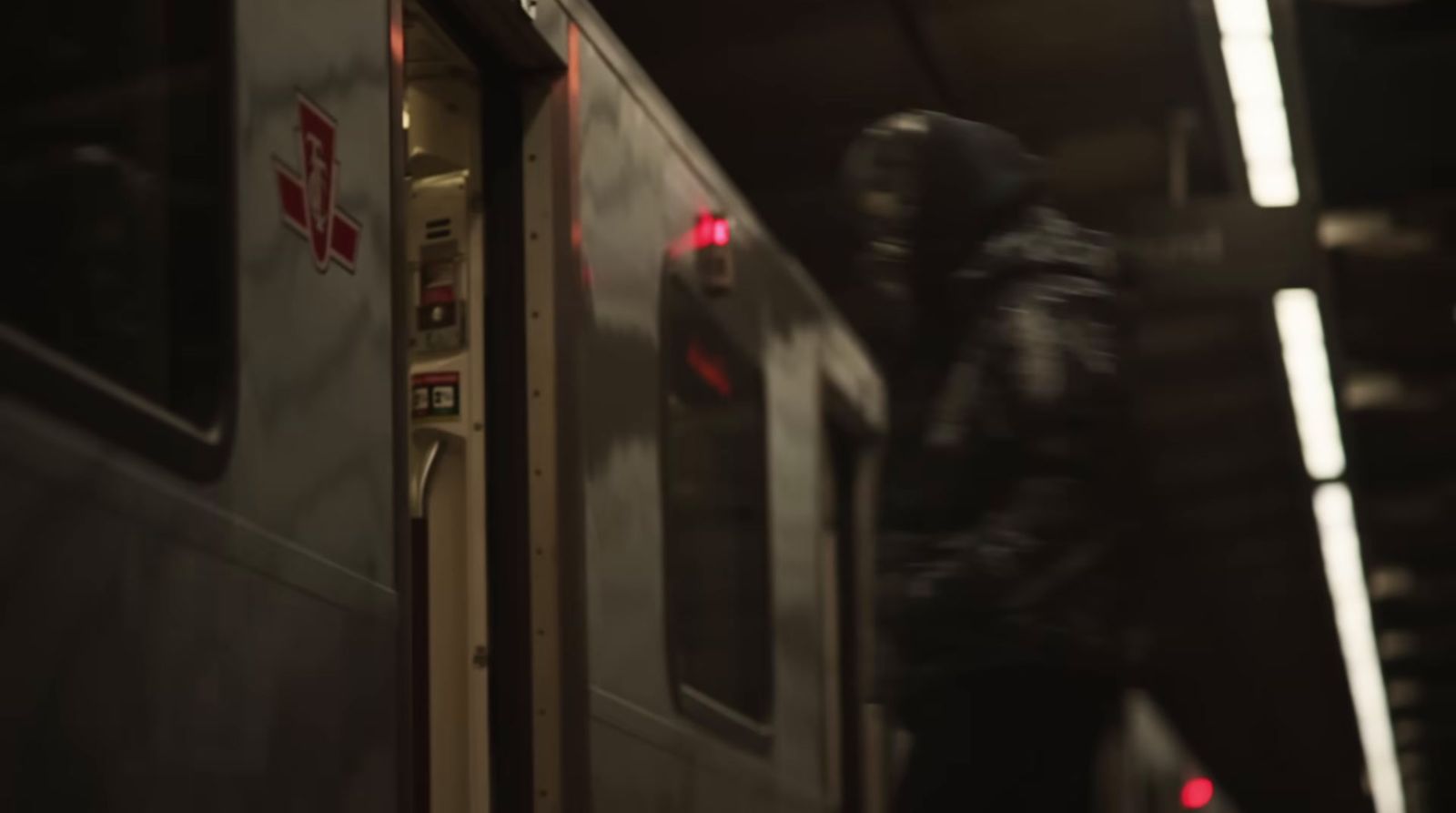 a man in a black jacket is standing next to a train