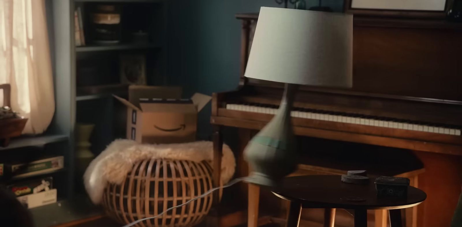 a living room with a piano and a lamp